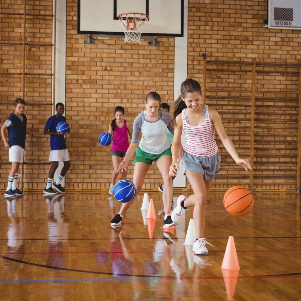 High School Kids Practicing Football Using Cones For Dribbling